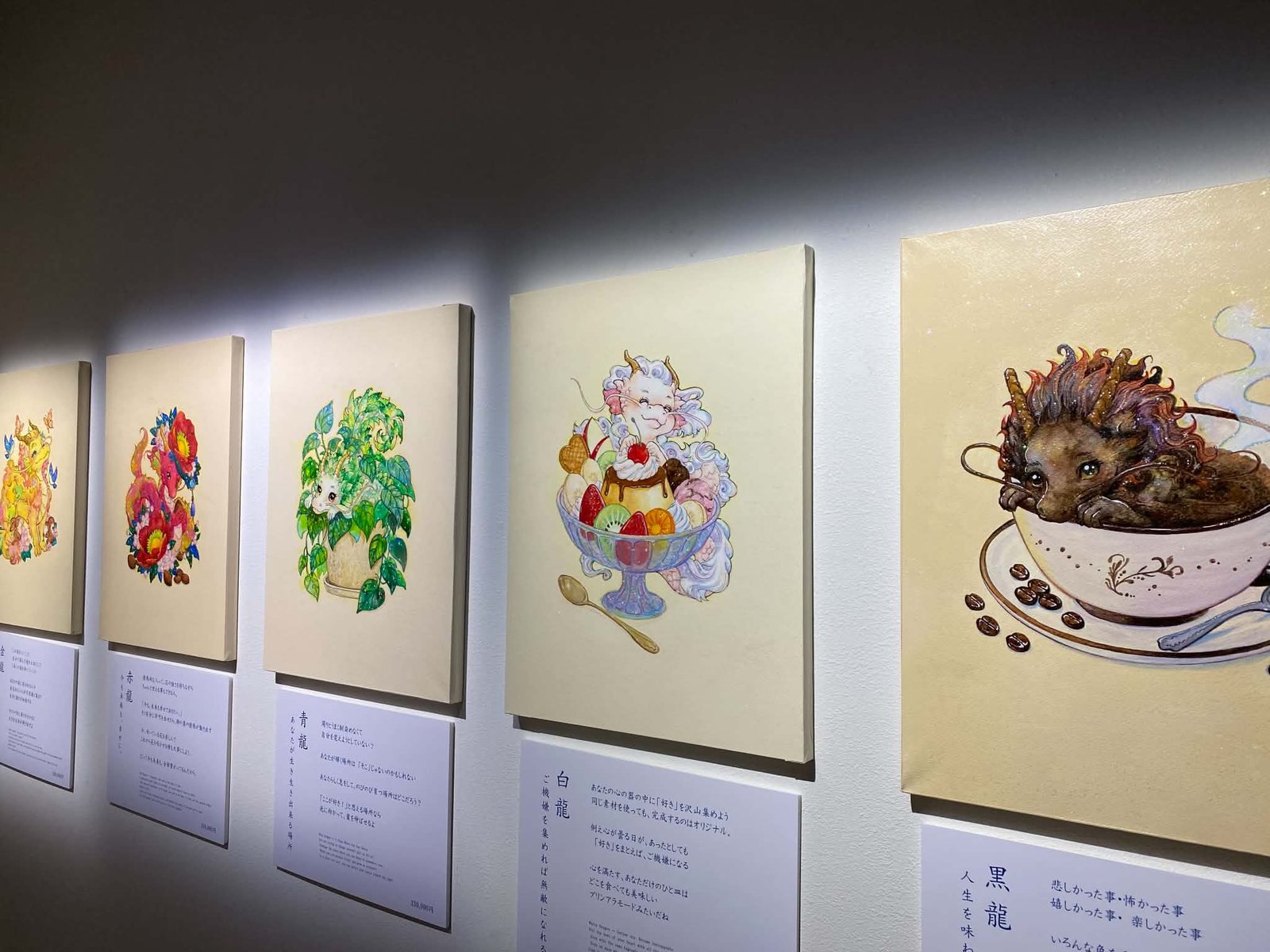 判多優実の展示の様子。花やパフェ、コーヒーカップと組み合わせた色とりどりの龍の作品が壁に並んでいる